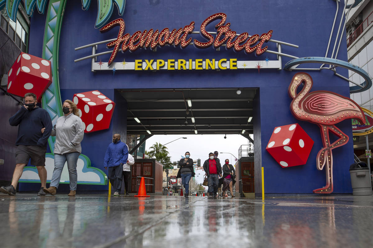 Visitors to downtown enter Fremont Street Experience after Clark County issued a severe thunder ...