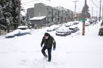 John Kramer walks down 42nd Avenue South in Columbia City as heavy snow blankets the Seattle ar ...