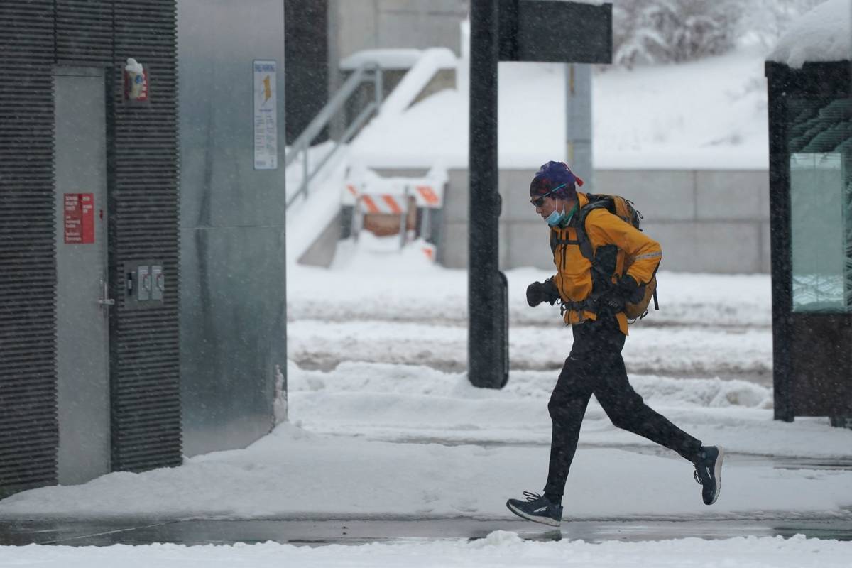 A person runs in the snow, Saturday, Feb. 13, 2021, on the University of Washington campus in S ...