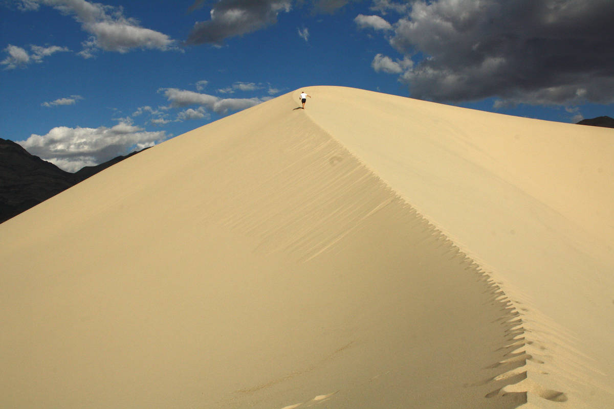 A hiker makes his way up the soft sand at Eureka Dunes. (Deborah Wall)