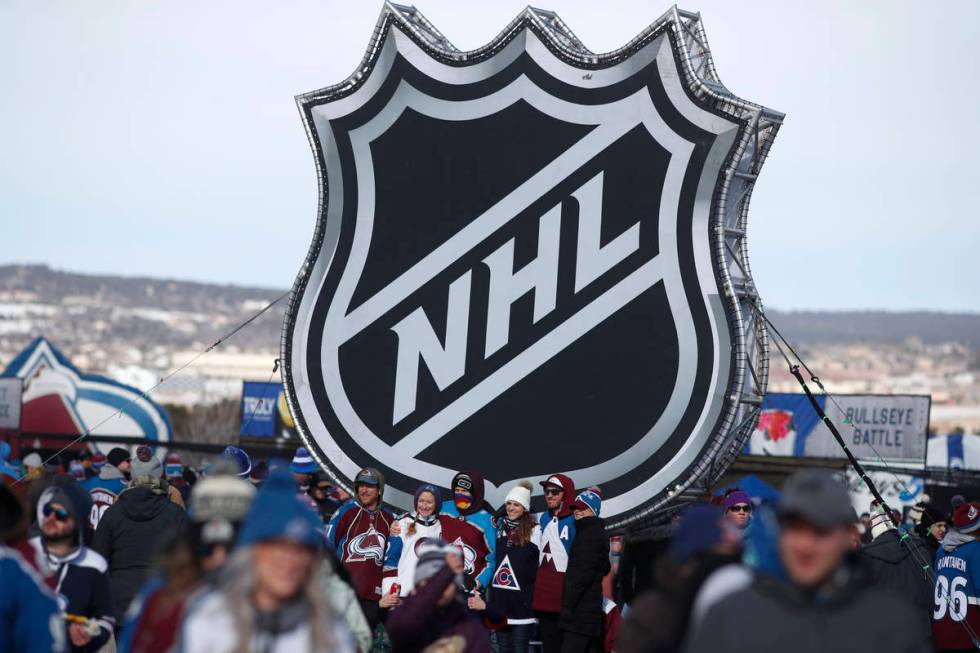 FILE - In this Feb. 15, 2020, file photo, fans pose below the NHL league logo at a display outs ...