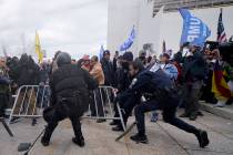 Police try to retrieve a barricade during a scuffle with President Donald Trump supporters at t ...