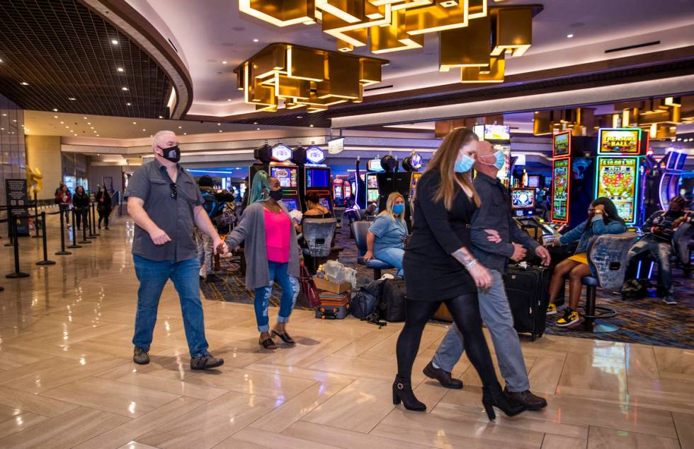 Couples pass by slot machines and the front desk area as casino floors have moved up to 35% occ ...