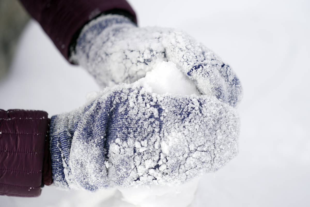 Cristina Lucero's hands are covered in snow while building a snowman Monday, Feb. 15, 2021, in ...