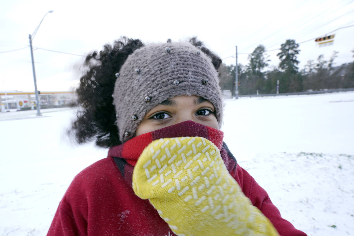Alyssa Remi, 12, tries to keep warm while playing in the snow Monday, Feb. 15, 2021, in Houston ...