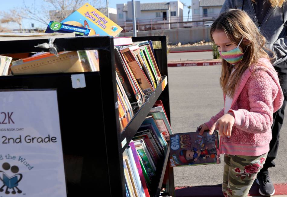 Kindergartner Olive Cantey, 6, chooses books during a school supply distribution event at McCaw ...