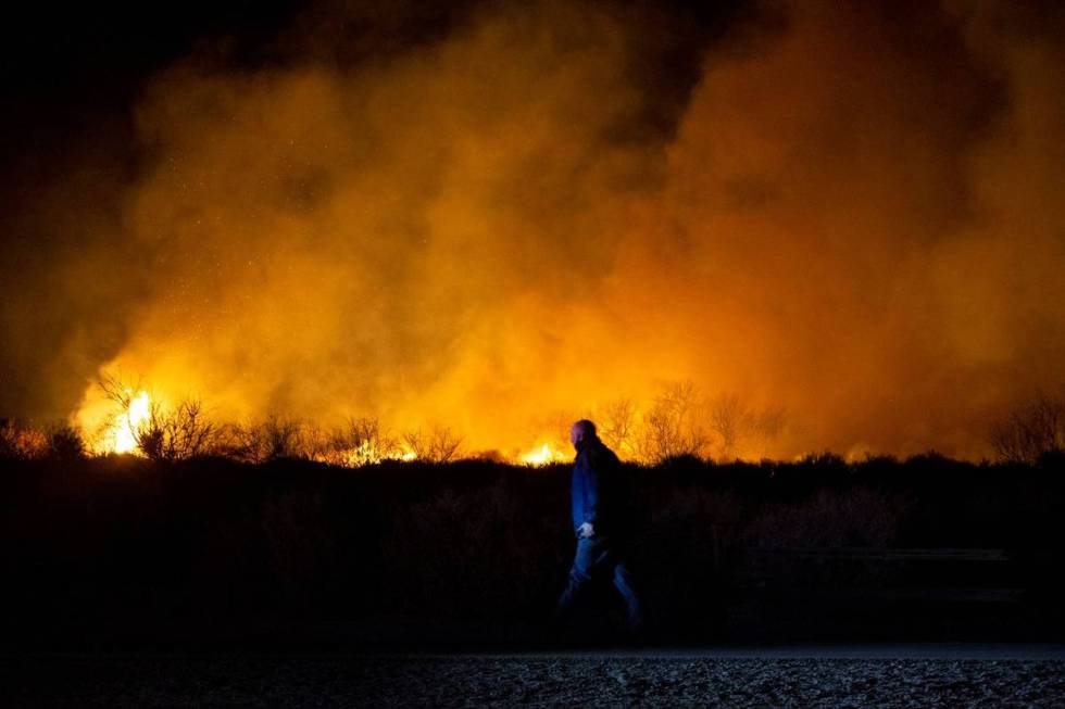 Law enforcement roams the perimeter of a brush fire burning at Clark County Wetlands Park on We ...