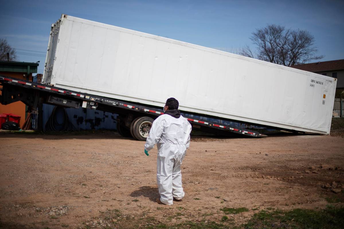 Gravedigger Thomas Cortez watches as a refrigerated trailer is delivered at the Hebrew Free Bur ...