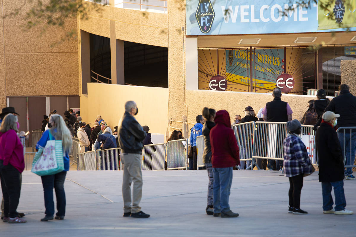 People wait in line for their COVID-19 vaccine at Cashman Field on Saturday, Feb. 20, 2021, in ...