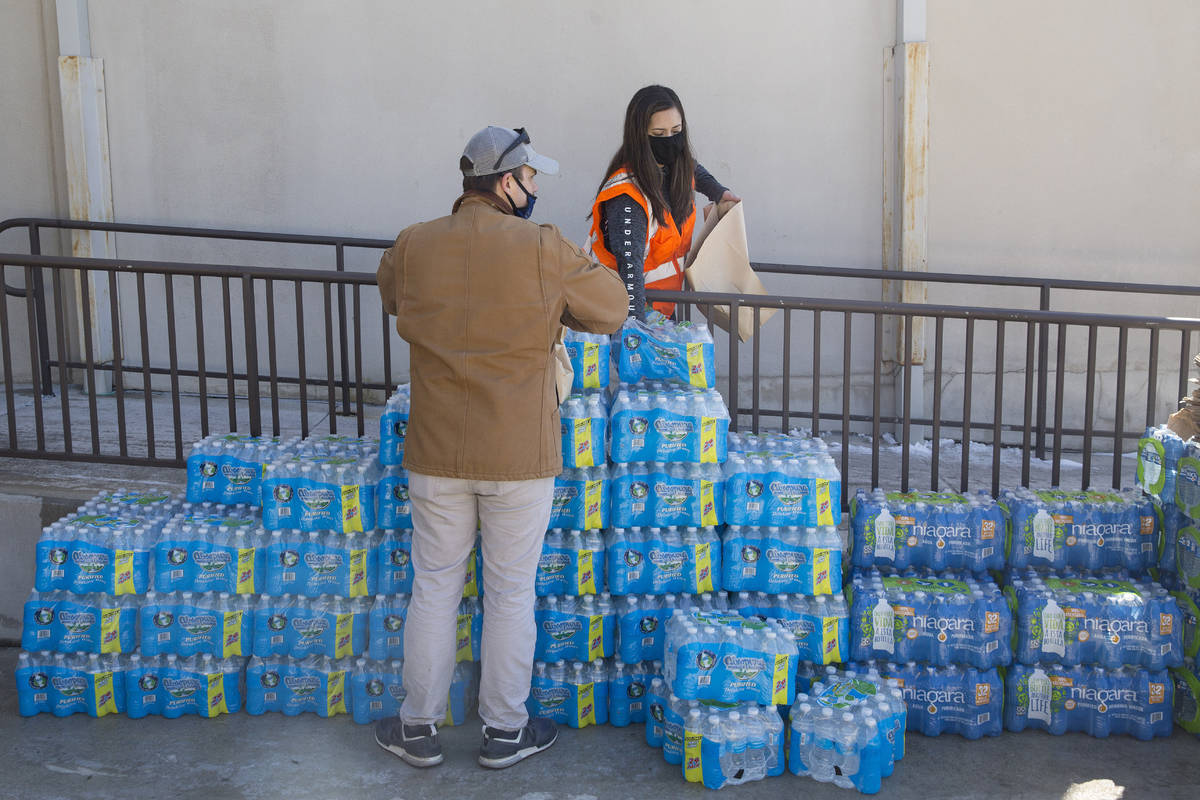 New Braunfels Utility employees help package bottled water at the water station at the New Brau ...