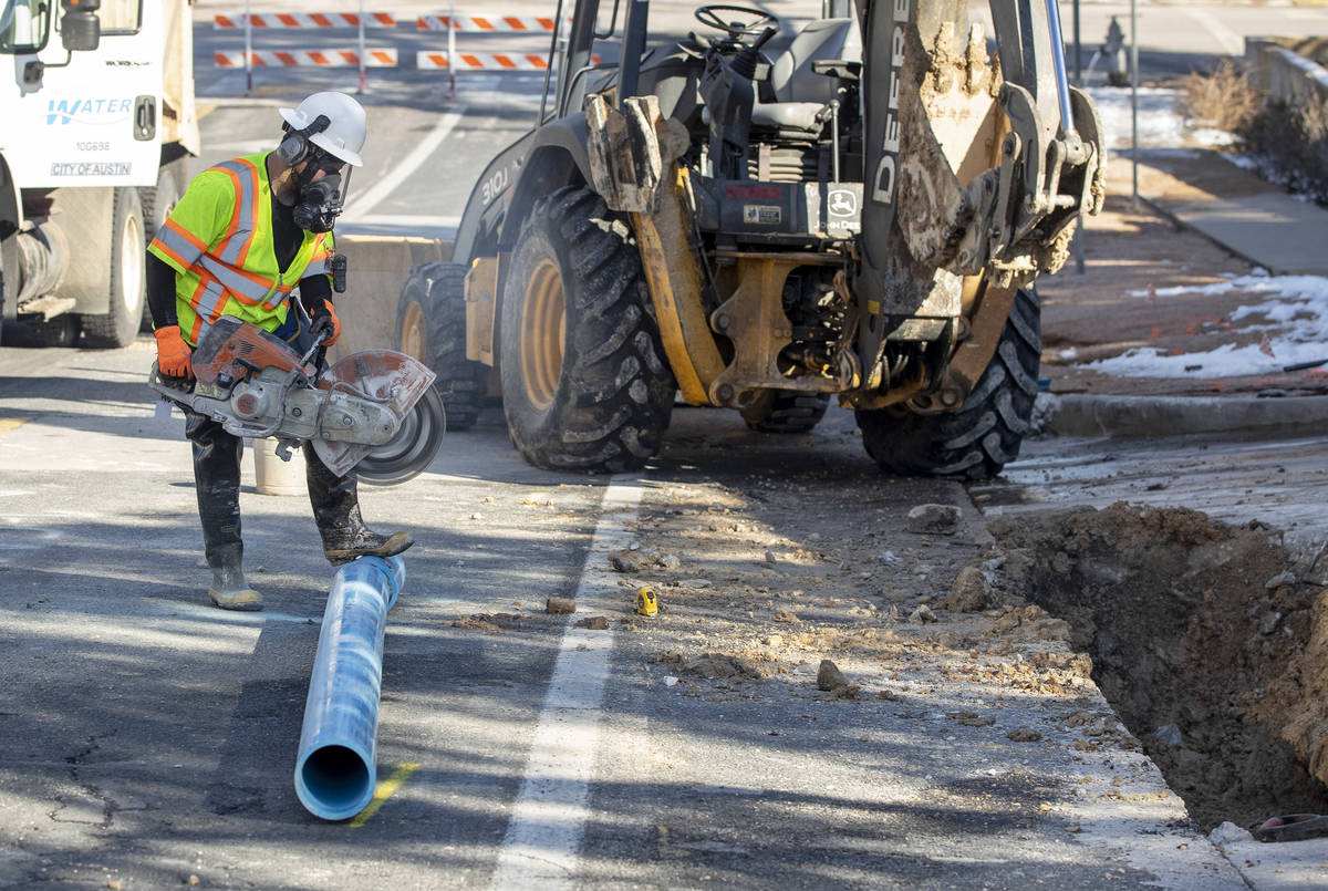 City of Austin Water Utility worker Salvador Tinajero repairs a broken water main near 11th and ...
