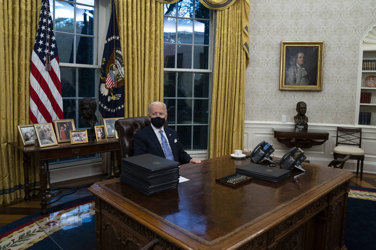 President Joe Biden signs a series of executive orders in the Oval Office of the White House, W ...