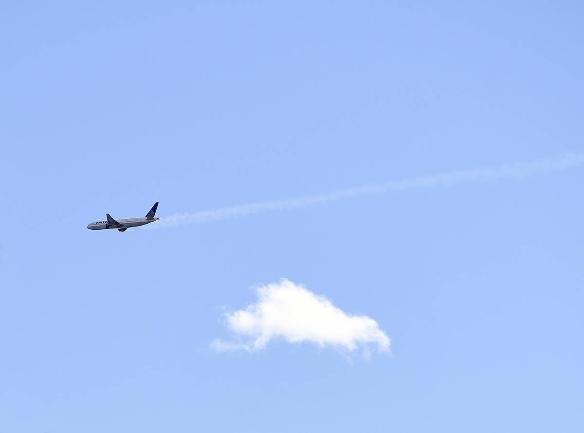 A United Airlines plane with smoke trailing from its right side is seen heading east towards De ...