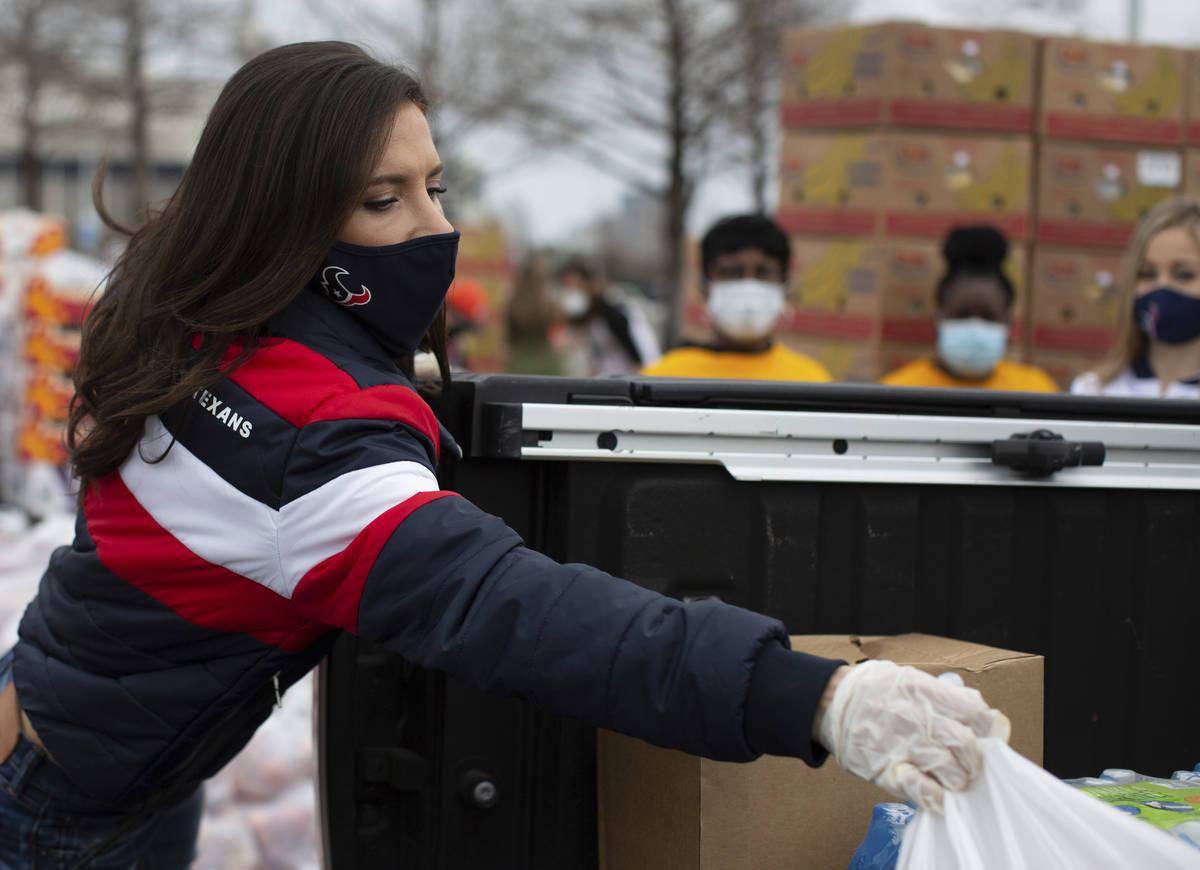 Texans' Hannah McNair distribute supplies during the Neighborhood Super Site food distribution ...