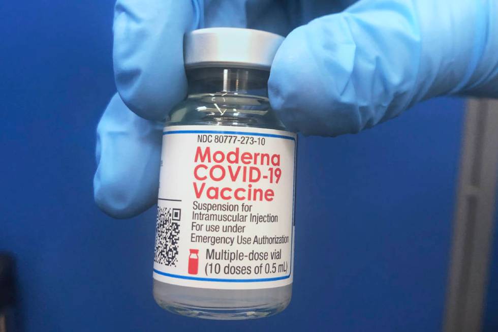 A vial of Moderna COVID-19 vaccine is held at a vaccination site Friday, Feb. 19, 2021, in Okla ...
