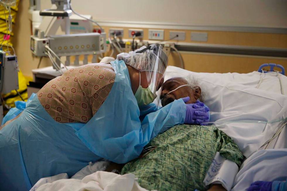 In this July 31, 2020, file photo, Romelia Navarro, 64, weeps while hugging her husband, Antoni ...