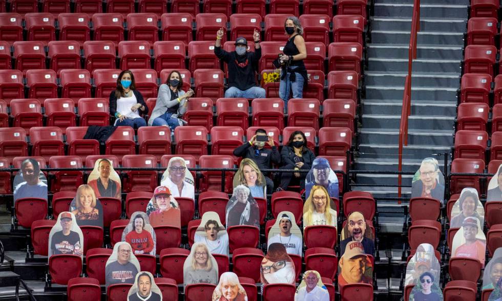 Some of the 100 fans in the stands during the first half of an NCAA menÕs basketball game ...