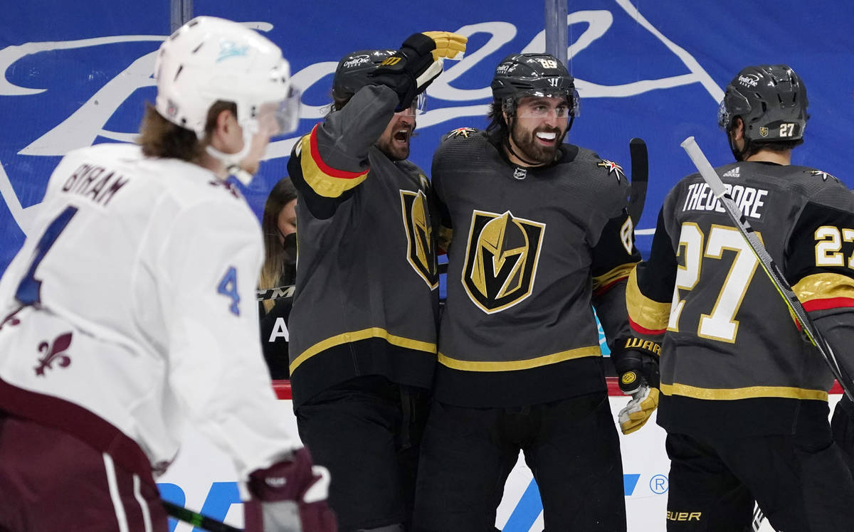 Vegas Golden Knights right wing Alex Tuch, back center, celebrates his goal with right wing Mar ...