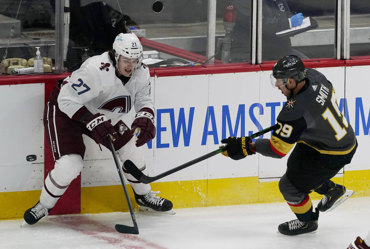 Vegas Golden Knights right wing Reilly Smith, right, passes the puck as Colorado Avalanche defe ...
