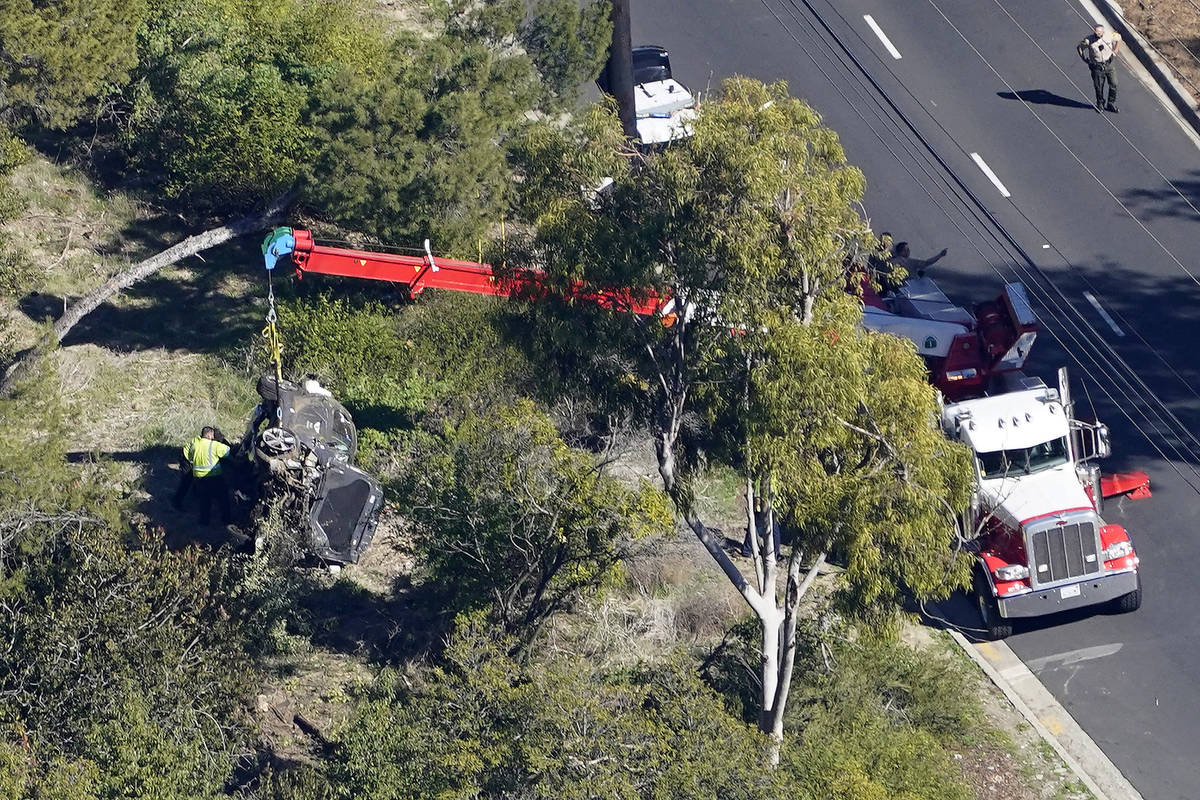 A crane is used to lift a vehicle following a rollover accident involving golfer Tiger Woods, T ...