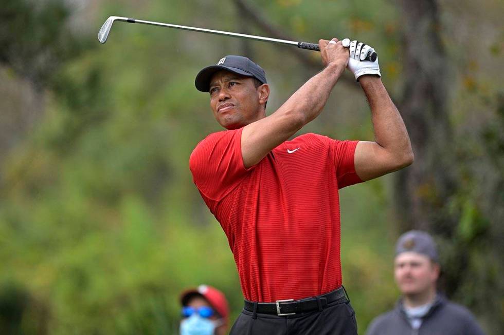 FILE - Tiger Woods watches his tee shot on the fourth hole during the final round of the PNC Ch ...