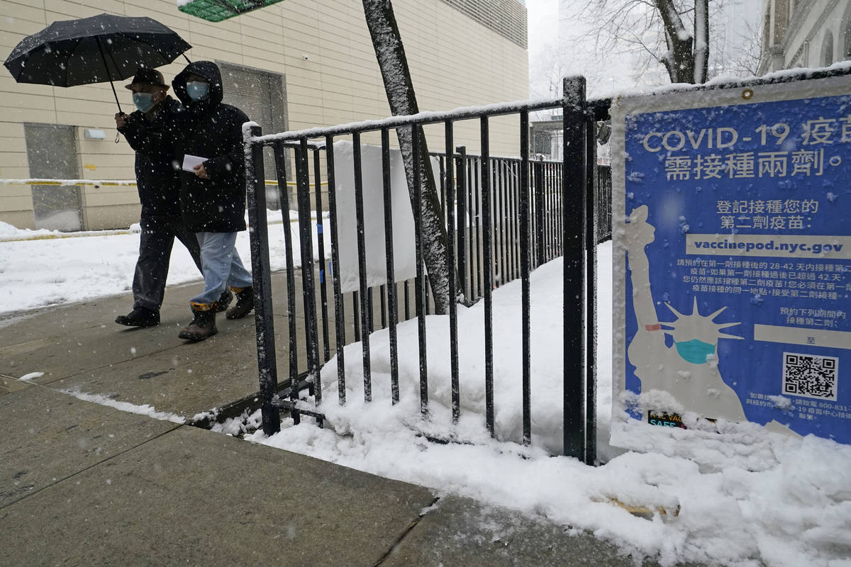 FILE - In this Feb. 7, 2021, file photo, two people enter a New York City vaccine hub during a ...