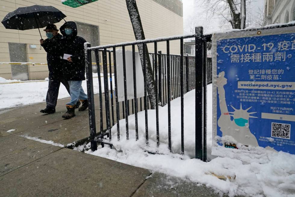 FILE - In this Feb. 7, 2021, file photo, two people enter a New York City vaccine hub during a ...
