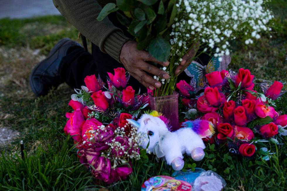 Brian Bradford arranges roses and flowers by the grave of his daughter, Briana Bradford, on the ...