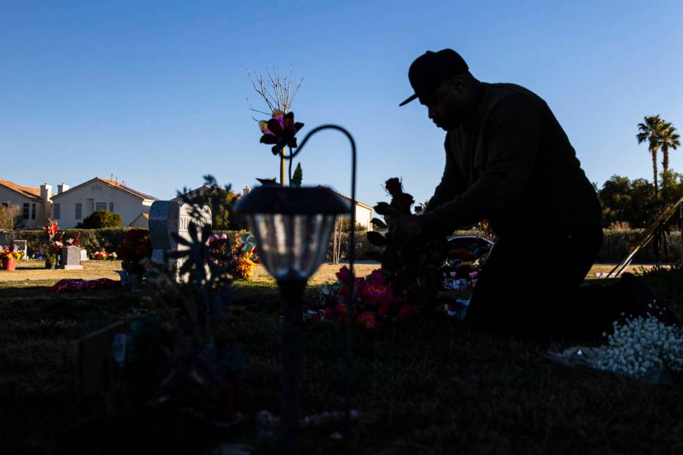 Brian Bradford arranges roses and flowers by the grave of his daughter, Briana Bradford, on the ...