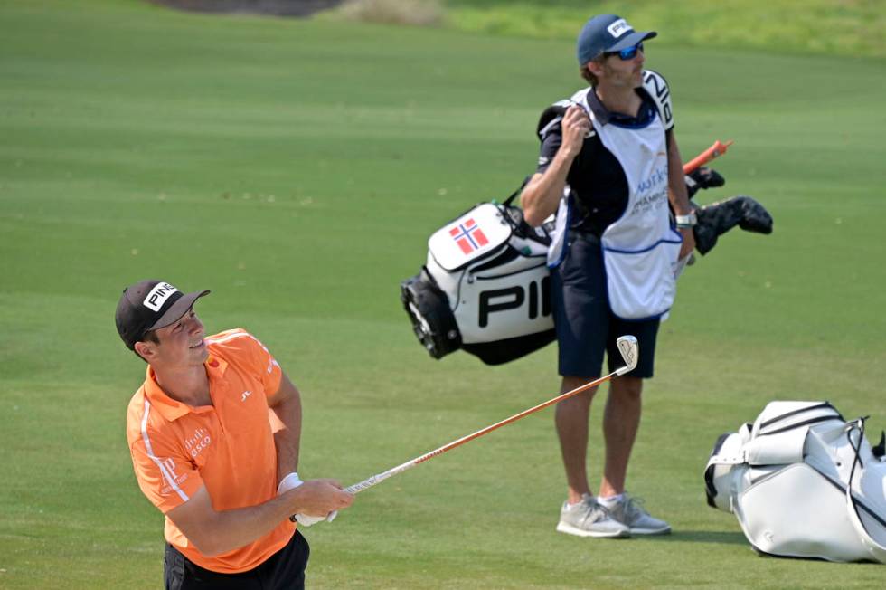 Viktor Hovland, of Norway, watches his shot from a bunker along the seventh fairway during the ...