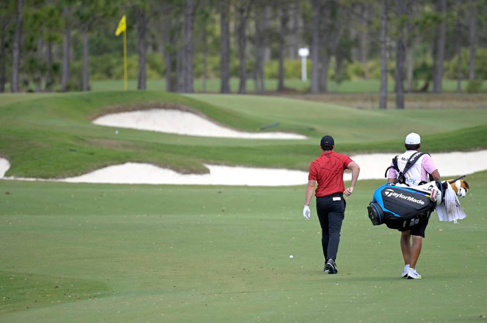 Rory McIlroy, of Northern Ireland, walks to his ball on the seventh fairway while wearing color ...