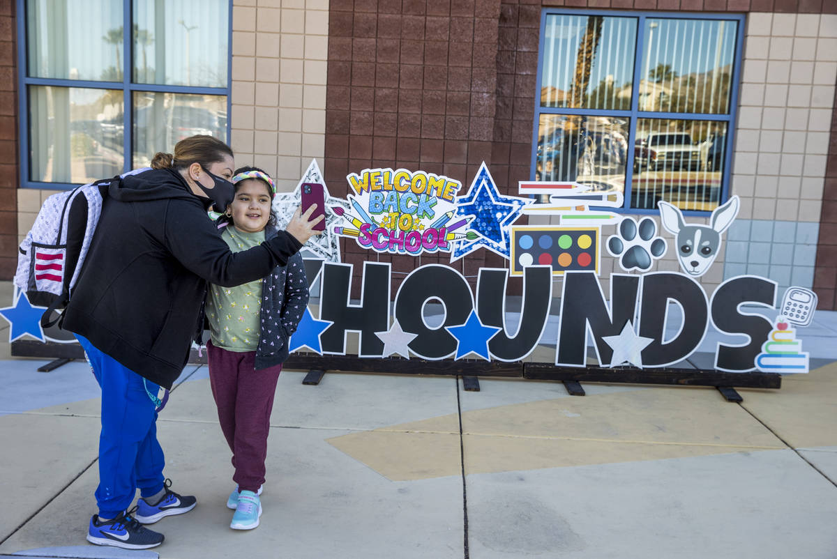 Lupe Tapia and her daughter Ariel, 8, take a photo outside of Goolsby Elementary School as she ...