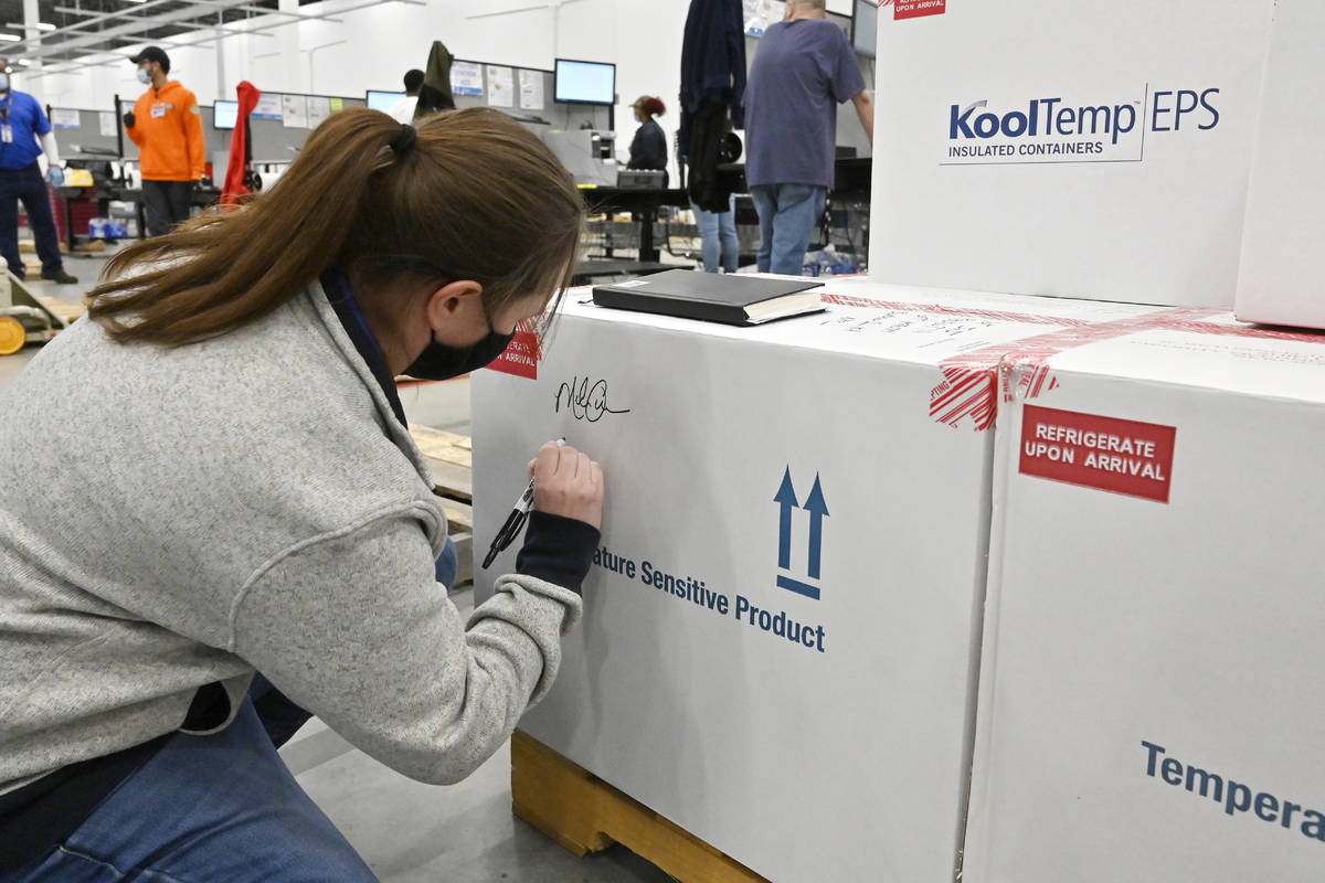 Melissa Owens, operations plant manager for the McKesson Corporation, signs the first shipping ...