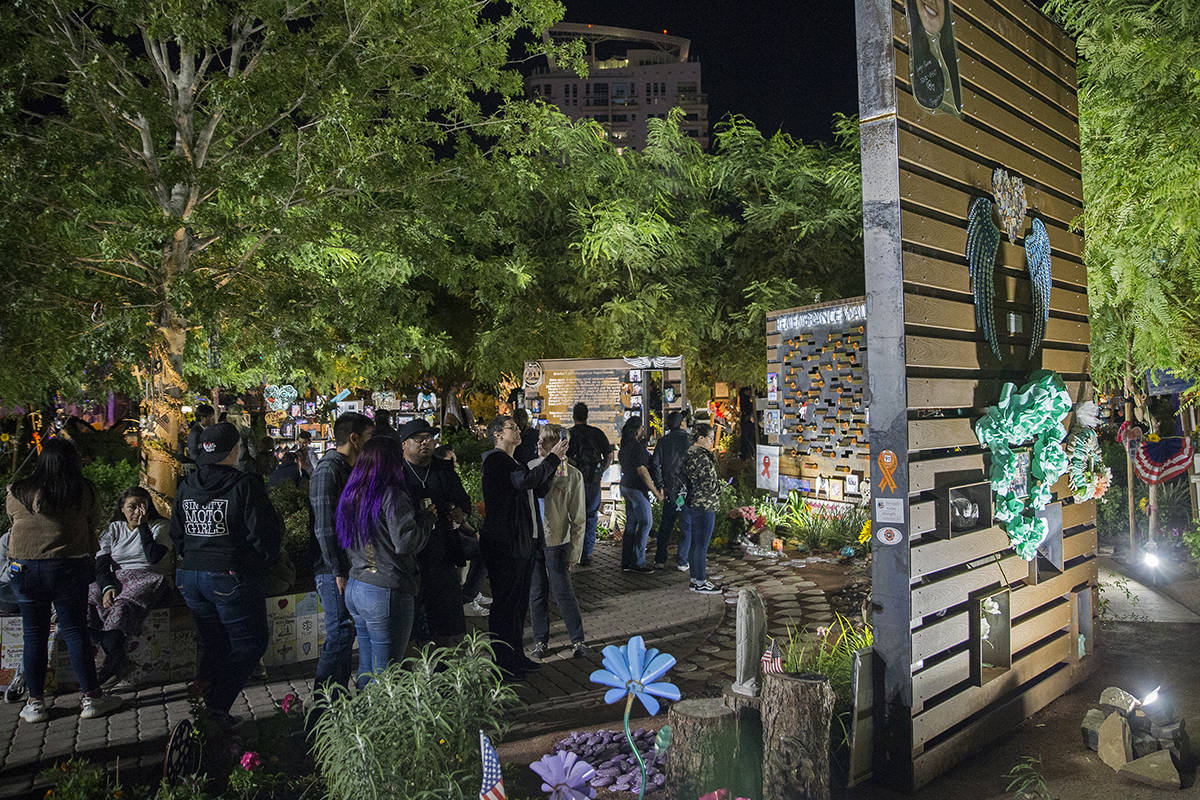 Visitors walk through the Las Vegas Community Healing Garden before the start of a ceremony hon ...
