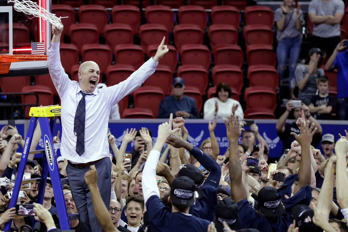 Utah State's head coach Craig Smith cuts off the net following an NCAA college basketball game ...