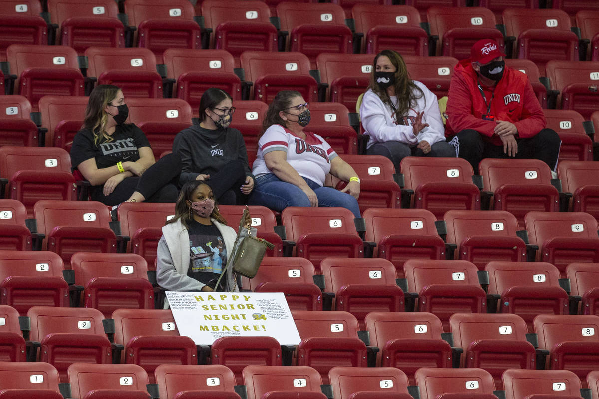 Fans sit in distanced seats during the second half of an NCAA men's basketball game between the ...