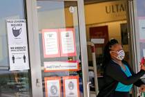 A customer exits a store with a mask required sign displayed, Tuesday, March 2, 2021, in Dallas ...