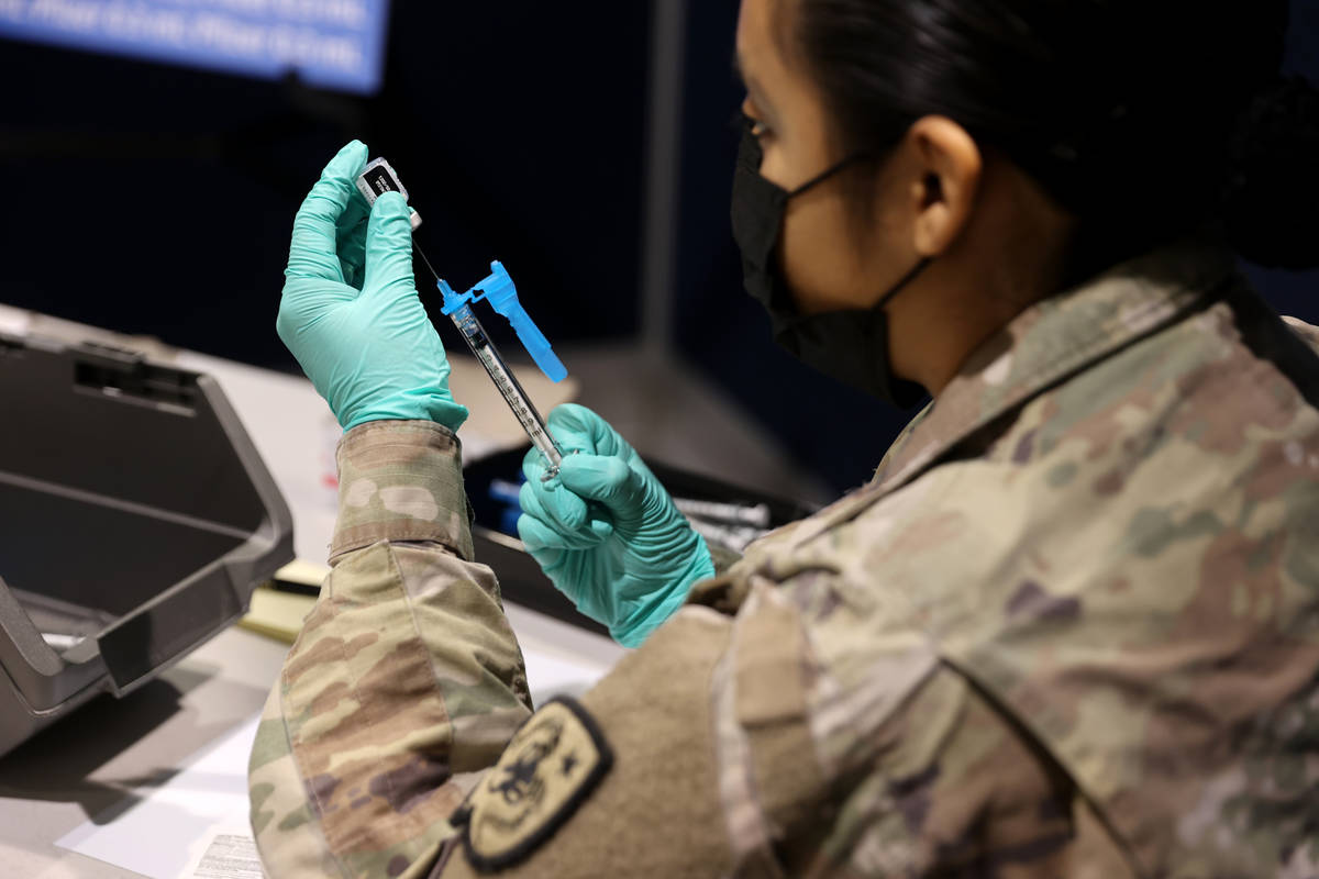 Nevada National Guard Pfc. Kimberly Hernandez prepares Pfizer vaccines at the Cashman Center CO ...