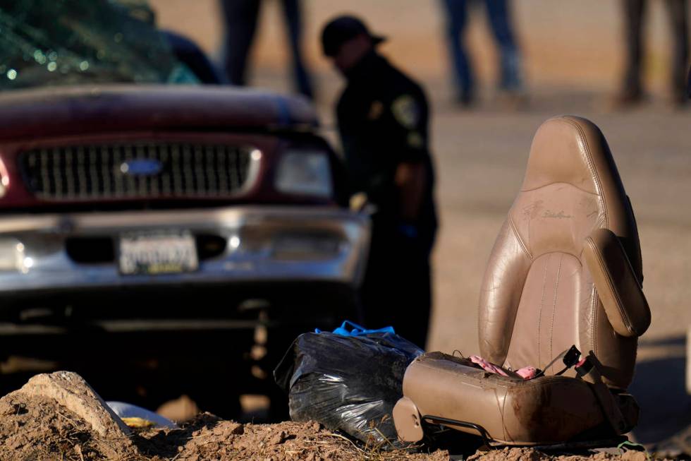 A law enforcement officer examines the scene of a deadly crash in Holtville, Calif., Tuesday, M ...