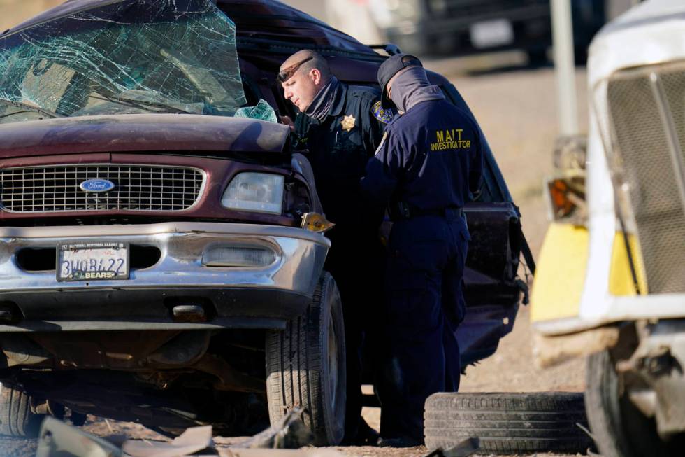 Law enforcement officers sort evidence and debris at the scene of a deadly crash in Holtville, ...