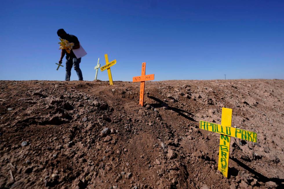 Hugo Castro leaves crosses at the scene of a deadly crash in Holtville, Calif., Tuesday, March ...