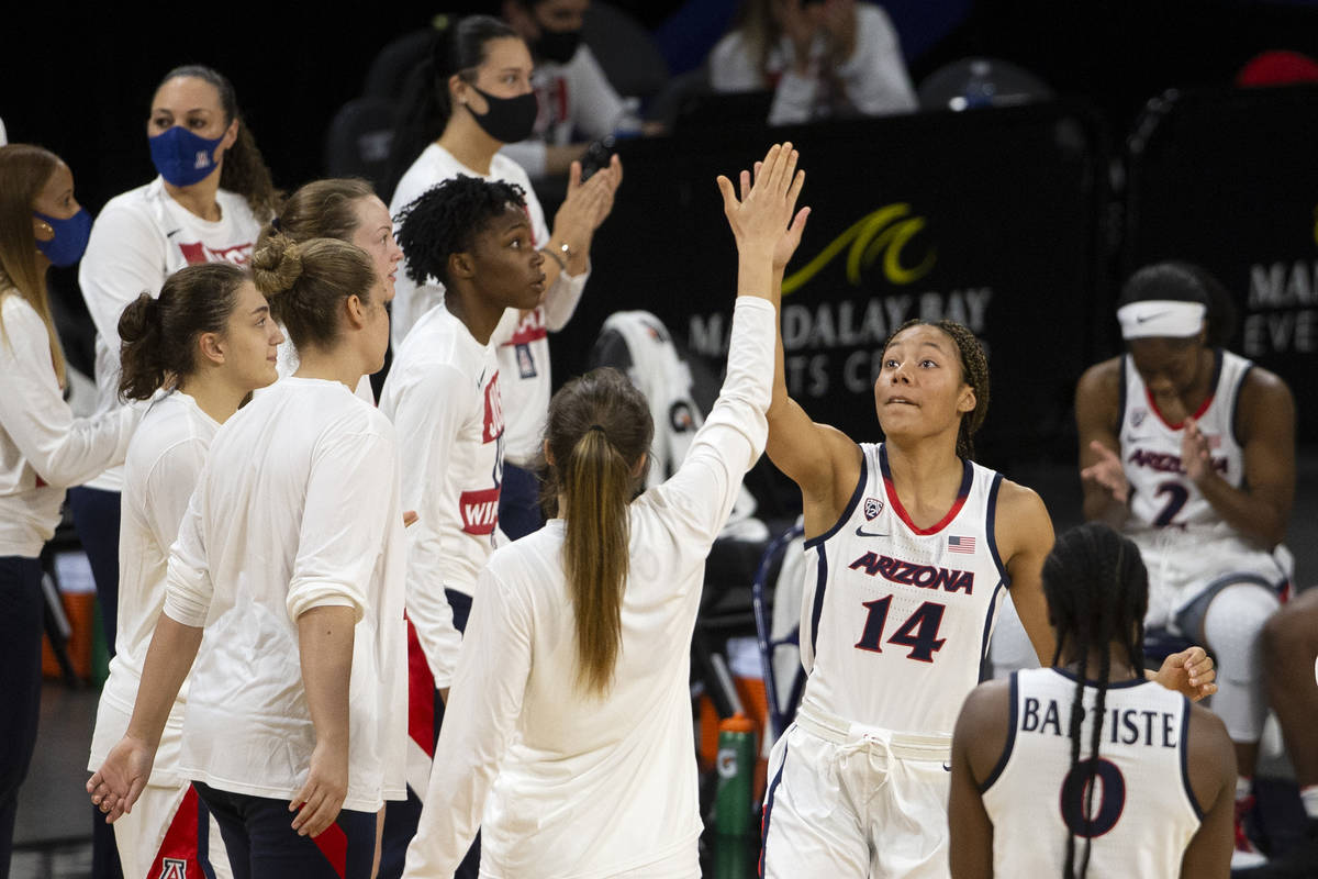 Arizona Wildcats forward Sam Thomas (14) high-fives her teammate guard Helena Pueyo (13) as sta ...