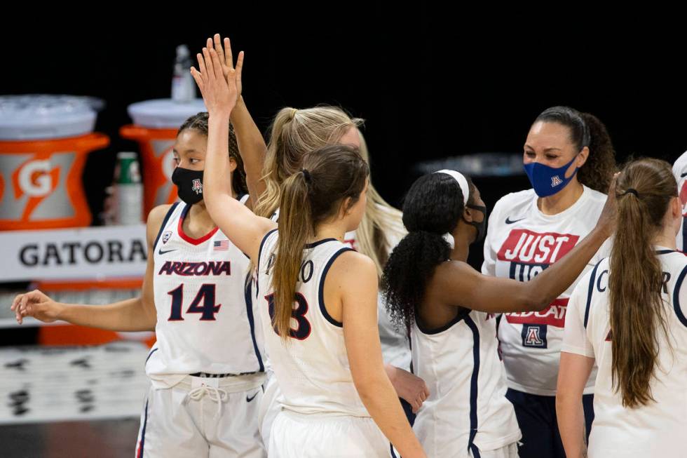 Arizona Wildcats forward Sam Thomas (14) and guard Helena Pueyo (13) high five while head coach ...