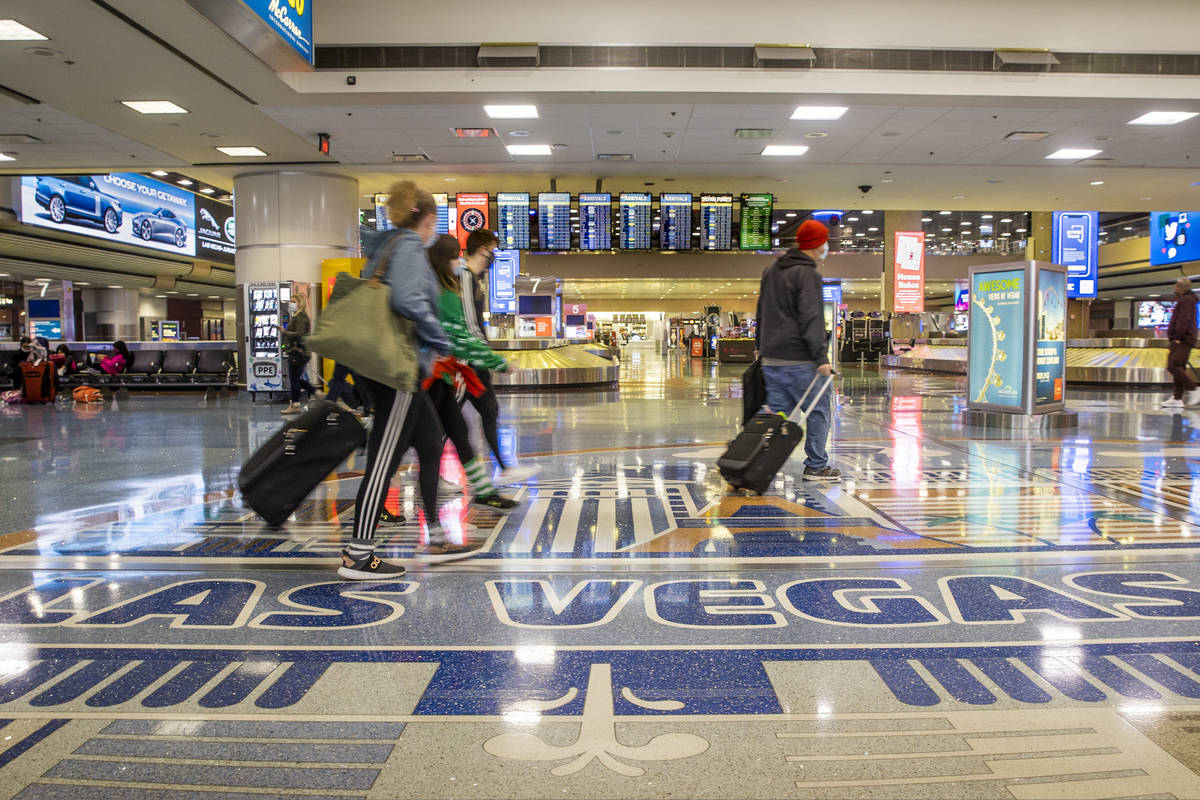 People come and go through baggage at Terminal 1 as holiday travel at McCarran International Ai ...