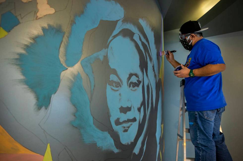 Artist Miguel Hernandez paints a mural in memory of Tony Hsieh in the lobby of ART HOUZ Theater ...