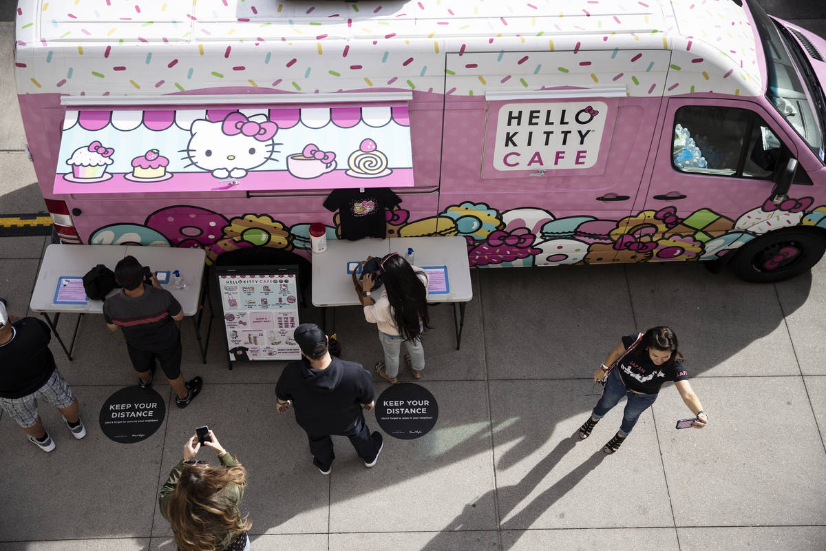 Kaye Anderson of Las Vegas, right, takes a photos in front of the Hello Kitty Cafe truck at Dow ...