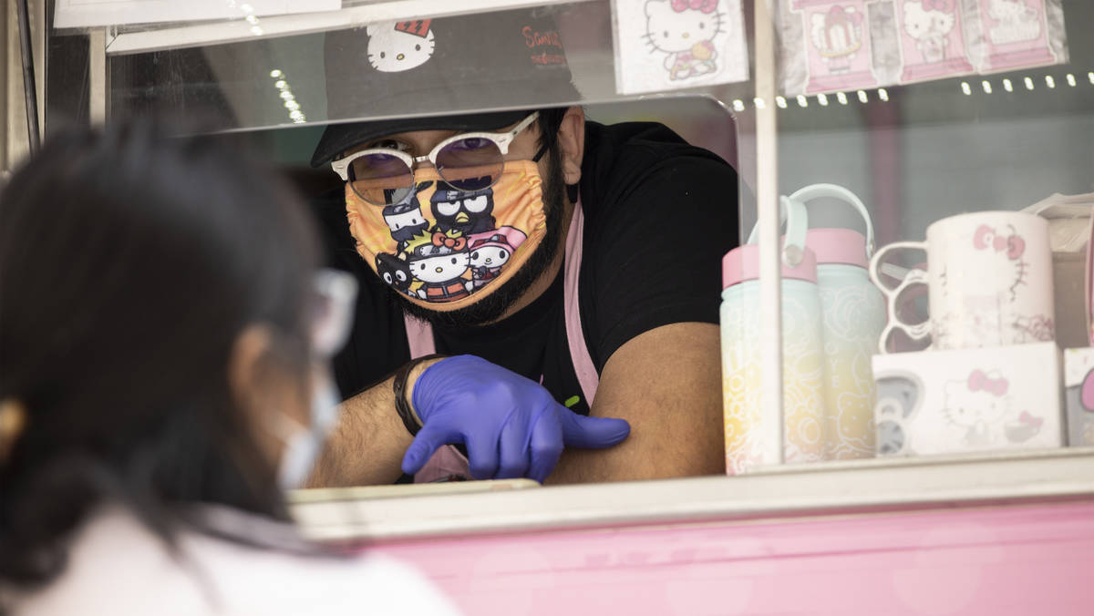 George Pulido assists a customer with her purchase from the Hello Kitty Cafe truck at Downtown ...