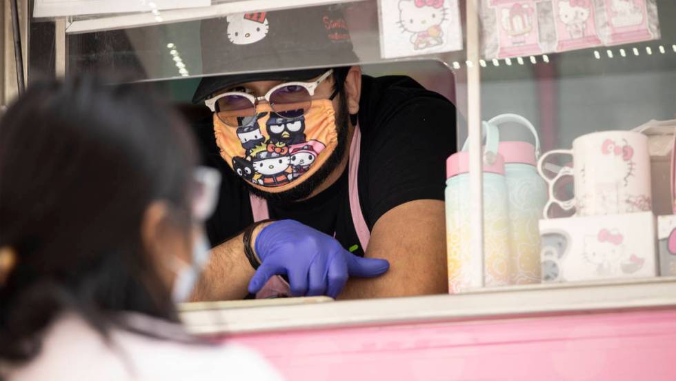 George Pulido assists a customer with her purchase from the Hello Kitty Cafe truck at Downtown ...
