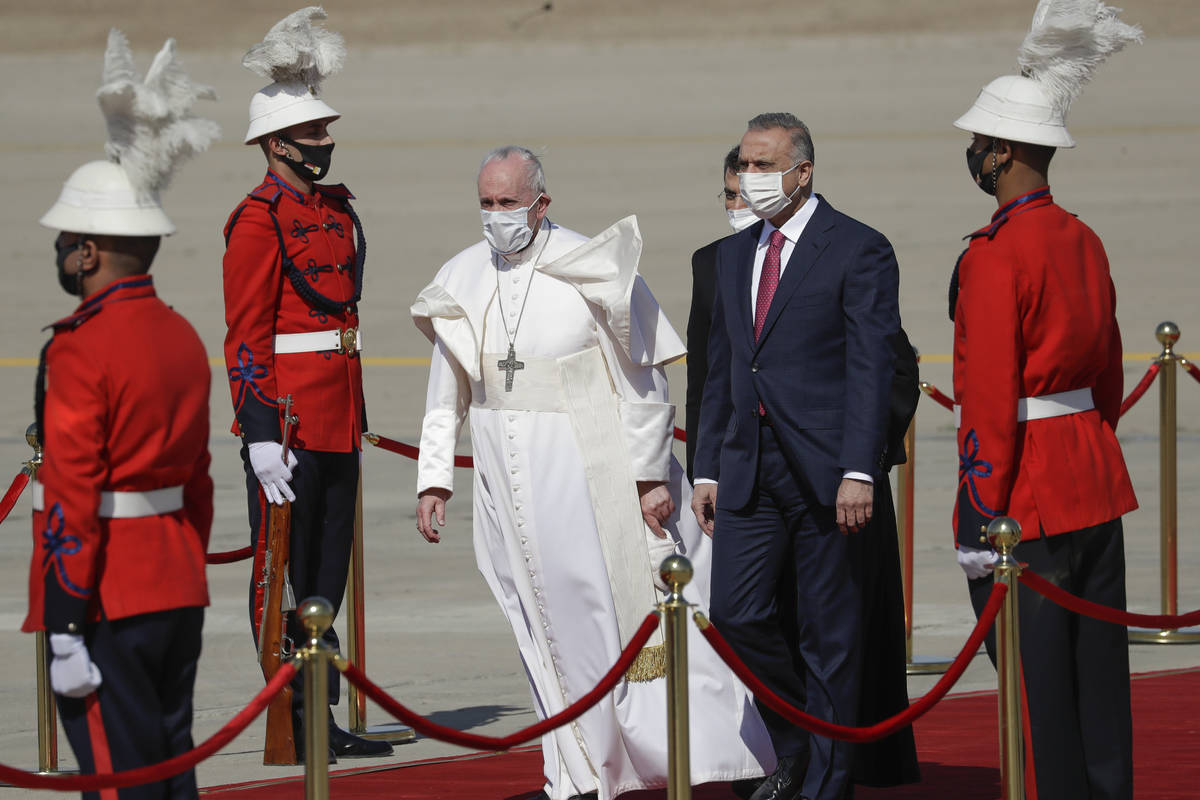 Pope Francis is flanked by Iraqi Prime Minister Mustafa al-Kadhimi upon his arrival at Baghdad' ...