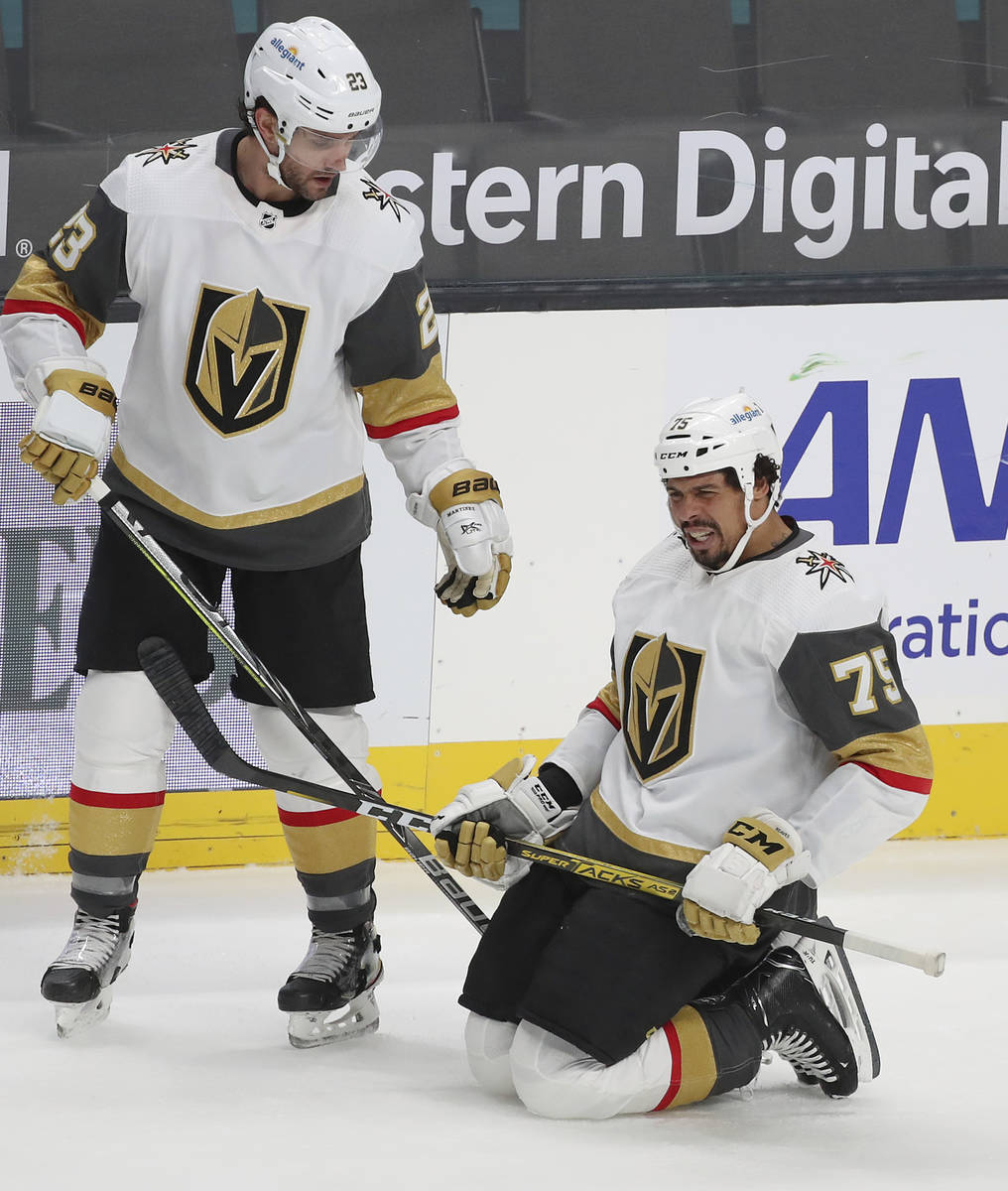 Vegas Golden Knights defenseman Alec Martinez (23) checks on injured right wing Ryan Reaves (75 ...